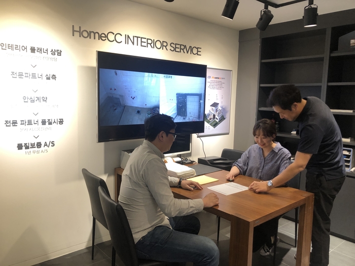고객이 홈씨씨인테리어 창원시티세븐점에서 인테리어플래너에게 인테리어 상담을 받고 있다.