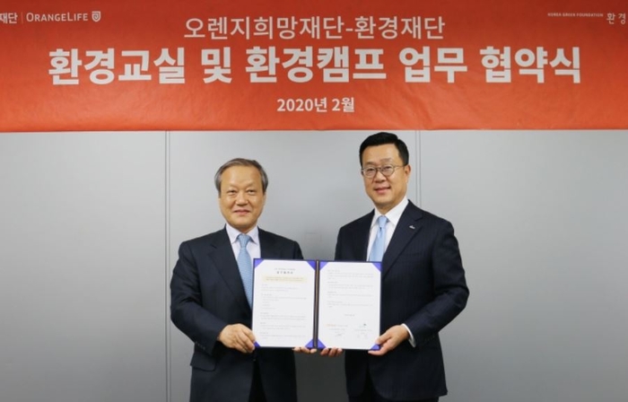 오렌지희망재단 정문국 이사장(오른쪽)과 환경재단 최열 이사장이 조인식을 마친 후 협약서를 들어보이고 있다. 사진=오렌지라이프