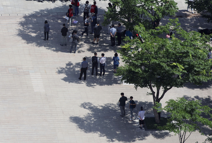 국이 대체로 맑고 무더위가 이어진 15일 오전 시민들이 서울광장 나무 아래 그늘에서 햇빛을 피하고 있다. /제공=연합뉴스